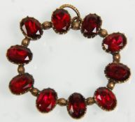 An Antique Victorian yellow gold brooch / pendant set with oval faceted cut garnets. Gross weight
