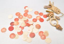 A collection of 19th Century antique bone gaming tokens, some being coloured red together with a