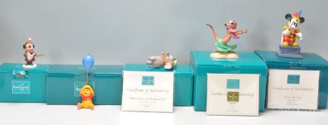 A group of five Walt Disney ceramic figurine ornaments to include Mickey Mouse Holiday 1998,