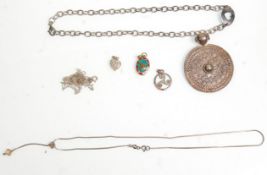 A group of silver ladies necklace chains and pendants to include a large round pendant with engraved