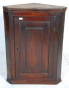 A 19th Century George III country  antique elm  hanging corner cabinet having a panelled door with
