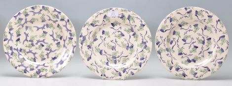 A group of three Emma Bridge water ceramic dinner plates each being hand painted with Scottish