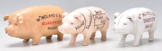 A group of three cast iron vintage advertising style piggy banks to include two W Molands Quaker