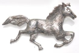 A stamped 925 silver brooch in the form of a galloping horse with a hinge pin to verso. Weight 7.2g.
