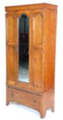 An early 20th Century 1930's oak wardrobe having three domed panelled doors, the central door having