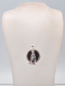 A stamped sterling silver pendant necklace having a fine link chain with a pendant in the form of