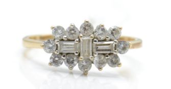 A hallmarked 9ct gold and white stone cluster ring. The ring set with baguette white stones
