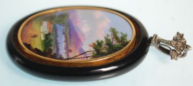 An antique Swiss pendant of oval form being set wi