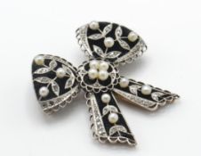 A French 18ct gold and platinum Belle Epoque brooch pin. The brooch in the form of a bow