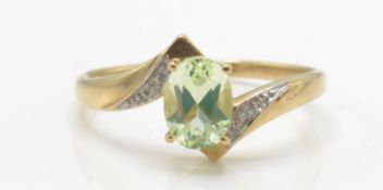 A 9ct quartz and diamond ring. The ring set with a central oval mixed cut stone