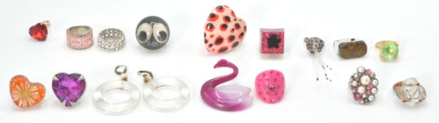 A collection of retro costume jewellery rings of plastic, composite and white metal construction. To