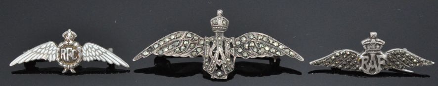 A group of three silver RAF brooches to include one with white enamelled wings (hallmarked