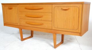 A mid century Danish inspired teak sideboard credenza being raised on tapering legs with a wide body