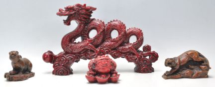 A collection of 20th Century Chinese figurines to include a faux cinnabar dragon clutching the