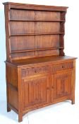 A 1930's oak dresser having carved decoration in the linenfold pattern to the panelled doors with