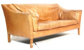A vintage retro style two seater sofa settee having a wooden frame with tan brown leather upholstery