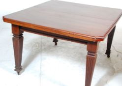 An Edwardian mahogany wind out dining table. The table being raised on tapering legs with castors