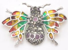 A stamped sterling silver and plique a jour brooch in the form of an insect set with marcasite and