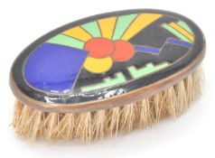 A lovely early 20th Century Art Deco miniature brush having an enameled top with a black ground