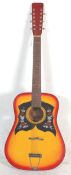 A vintage Korean made six string acoustic guitar having a sunburst finish body with dual scratch