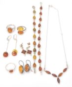 A collection of silver and amber set jewellery to include 3 amber cabochon set rings,  2 amber set