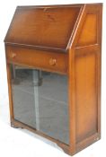 A vintage retro 20th Century fall front bureau bookcase having a sloping fall front desk opening