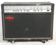 A large H||H Professional Power Guitar Amplifier Model COMBO raised on castors.