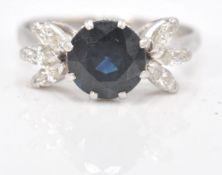 An impressive platinum ring with a sapphire in a cathedral setting flanked by 6 diamonds. Size 7.