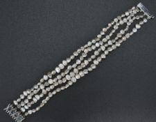 A 14ct white gold 585 4 strand baroque pearl bracelet by JKA . The bracelet united by a 14ct gold
