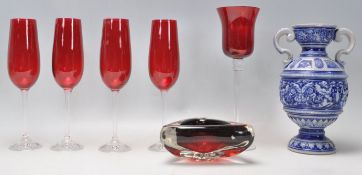 A matching group of four retro champagne flutes having red glass bowls and clear stems. Together