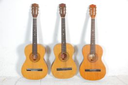 A group of three six string acoustic guitars. All guitars being Encore makes model ENC 36N having