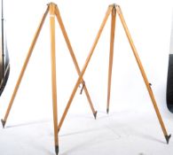 A good mid century pair of  retro wooden and cast metal surveyors tripod stands.The tapering wooden