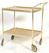 A retro 20th Century brass two tier tea trolley having formica teak wood effect tops. Raised on