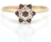 A 9ct gold ruby and diamond cluster ring. The ruby and diamond mixed cut stones in cluster setting