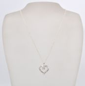 A 14 ct white gold diamond set heart shaped necklace with a cable chain and lobster clasp . Weighs