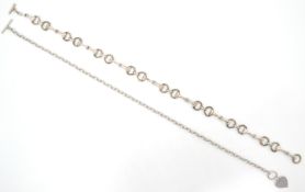 A large silver booklink necklace chain with hoop and t-bar clasp together with another necklace
