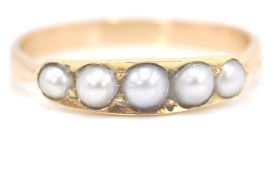 A 9ct gold and half pearl ring. The ring ( unmarked but tests as 9ct) with 5 channel set half