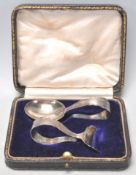 A silver hallmarked spoons and pusher set having empty cartouche handles. Both let within original