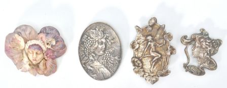 A collection of 4 Art Nouveau style brooches in white silver metal, possibly silver. To include a