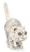 A stamped sterling silver ornament in the form of a pouncing cat set with emerald coloured eyes.