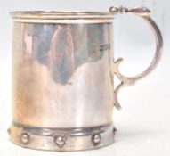An early 20th Century Edwardian silver hallmarked cup having a scrolled handle and ball decoration