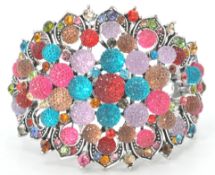 A contemporary silver and semi precious stone art nouveau style cuff bangle with a hinged clasp.