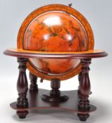 A Georgian style terrestrial desk globe supported in a wooden meridian ring and a finely decorated
