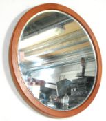 A vintage retro mid 20th Century circular teak framed hanging wall mirror having a bevelled edge