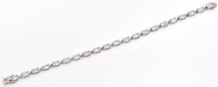 A stamped sterling silver and aquamarine stone line bracelet with the stones set in a repeating