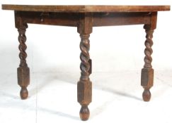 An early 20th Century draw leaf refectory dining table raised on block and barley twist supports