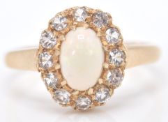 A 9ct gold Birmingham hallmarked opal and white stone ring. The cabochon opal within a halo of white
