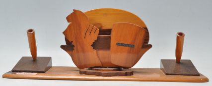 A retro mid century teak wood desk tidy of unusual form. Raised on a plinth base with a central