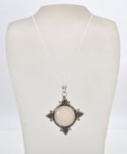 A stamped sterling silver pendant necklace with a large moonstone flanked by tourmaline and