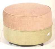 A retro mid century circular barrel foot stool pouffe in a two tone upholstered colourway of beige